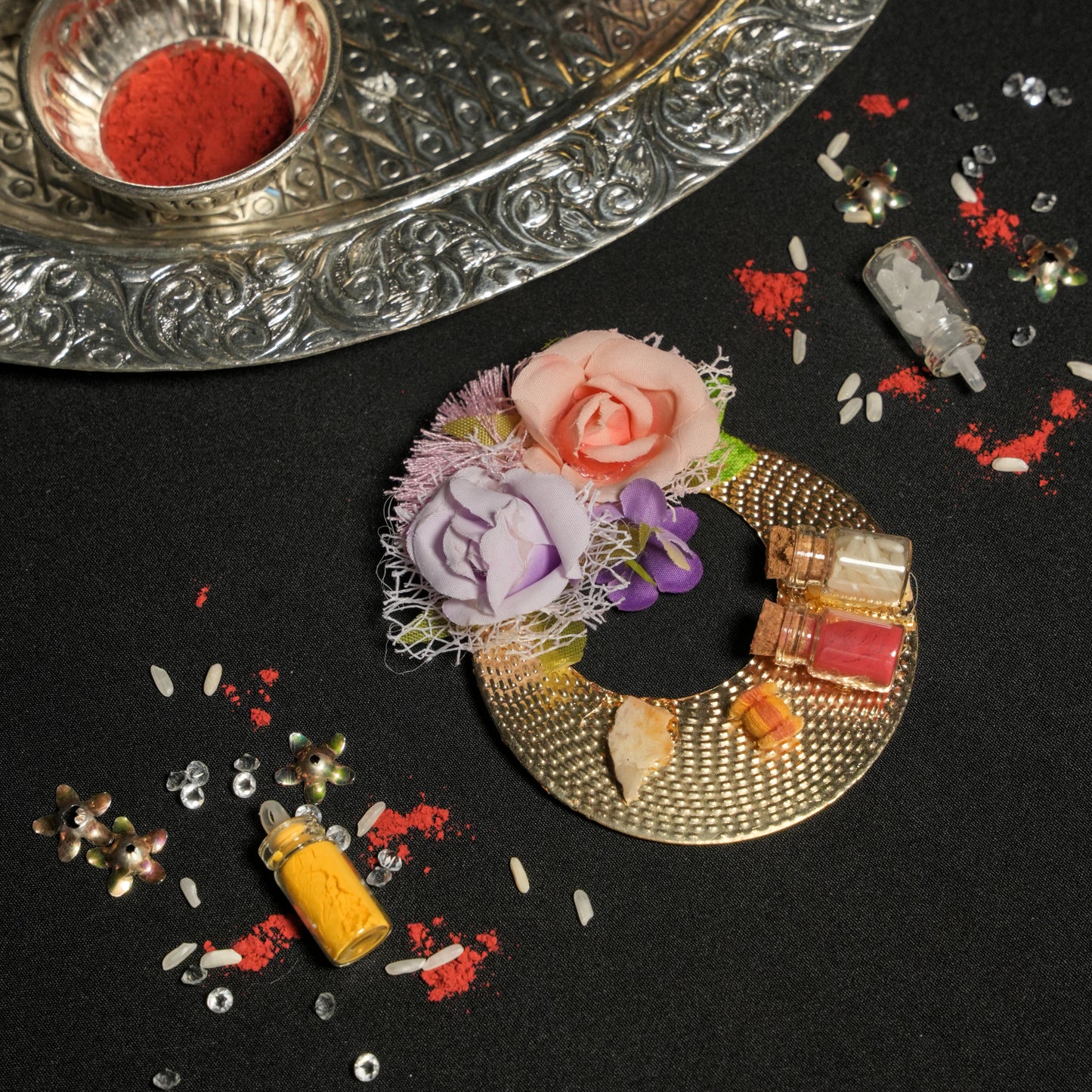 Roli Chawal on metal dics with floral arrangement